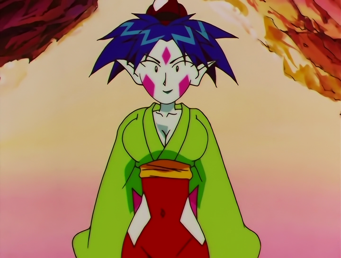 Ponko, a Lemures from Sailor Moon episode 144. She has pale white skin with three pink diamonds painted on her face, and dark blue hair. Her outfit is green and red, and we see her here after having eaten the Balls That Give You Boobs. You can’t see it here, but she also has a long tail.